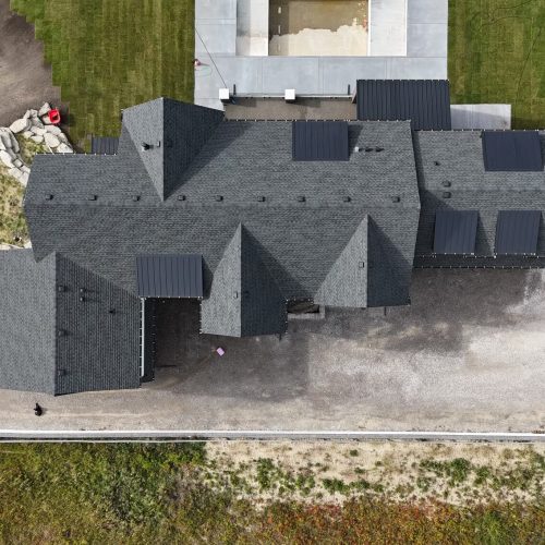 Overhead view of residential home showing black shingle roofing.