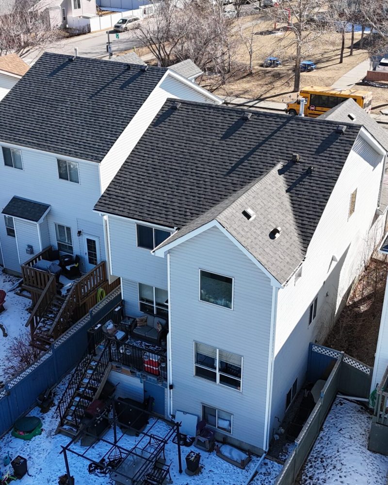 Modern neighborhood homes in Calgary featuring dark roofing systems.